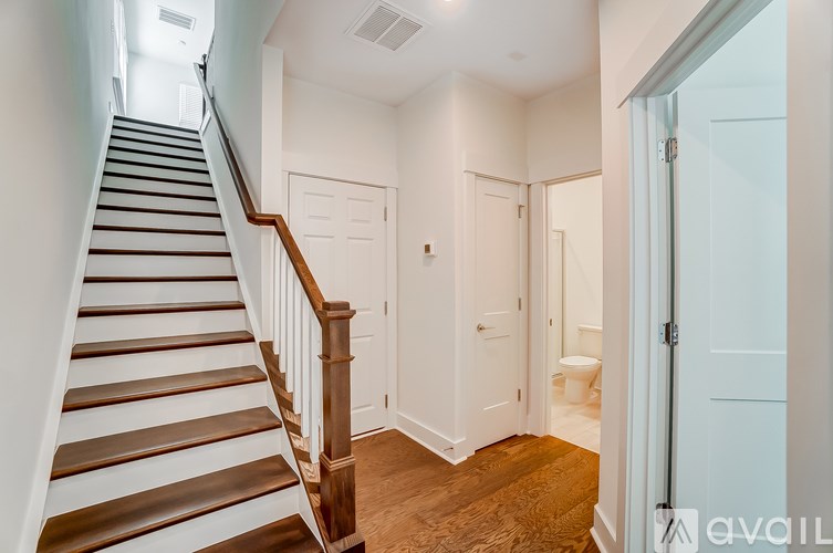 A staircase with white walls and wooden steps.