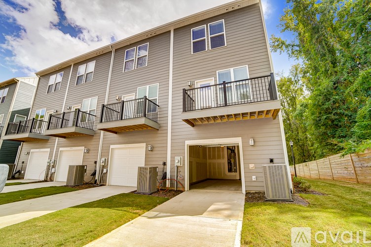 A modern two-story apartment building with balconies and garages.