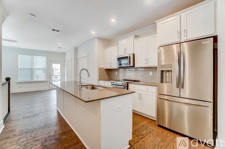 A modern kitchen with stainless steel appliances and white cabinets.
