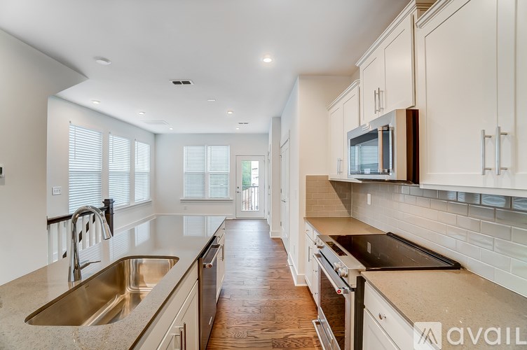 A kitchen with a sink, stove, and cabinets.