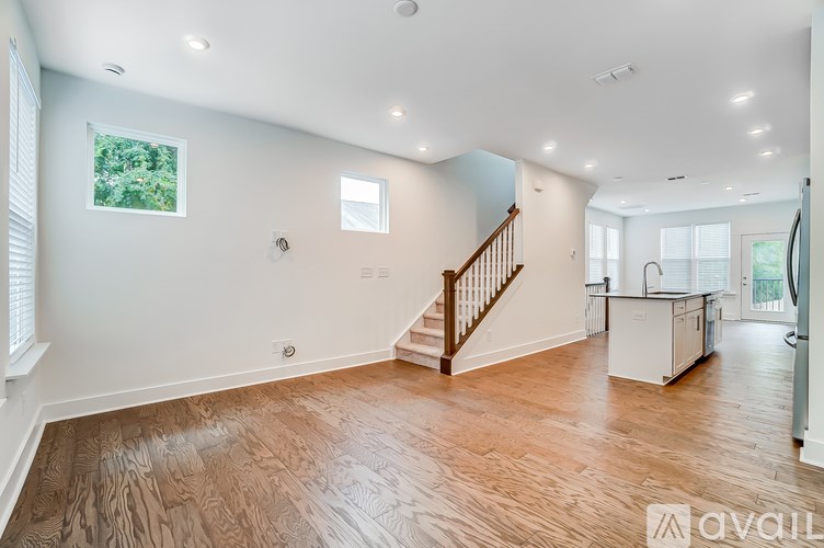 A spacious living room with a staircase leading to the upper floor.