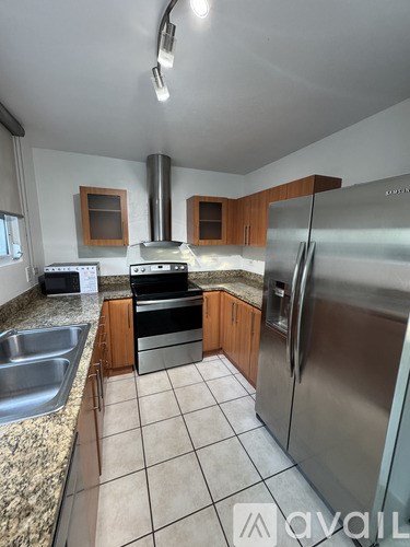 A kitchen with a stove top oven and a refrigerator.