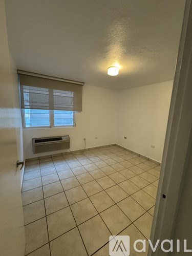 A room with tiled flooring and a window with blinds.