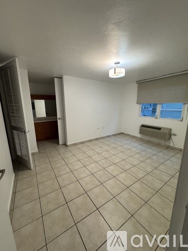 A room with tiled flooring and a window with blinds.