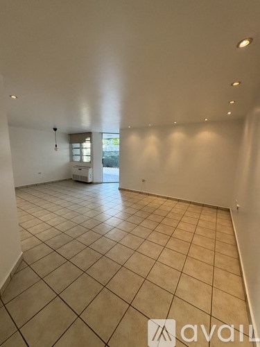 A spacious room with tiled flooring and a window.