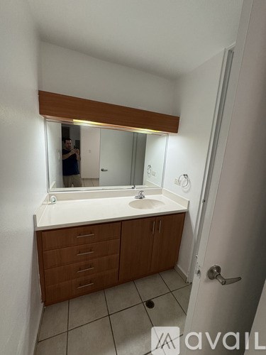 A bathroom with a sink, mirror, and cabinet.