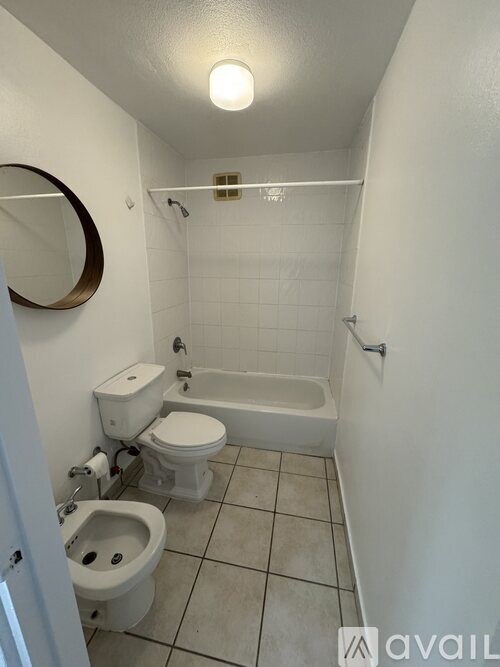 A bathroom with a toilet, a bidet, and a bathtub.