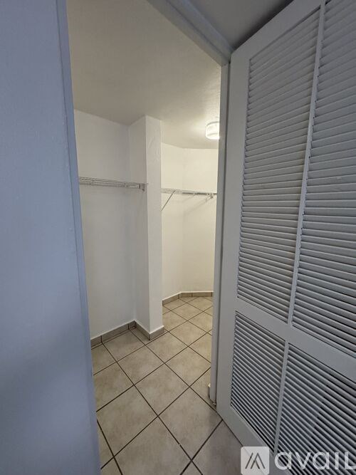 A white door with a window is open to a hallway.