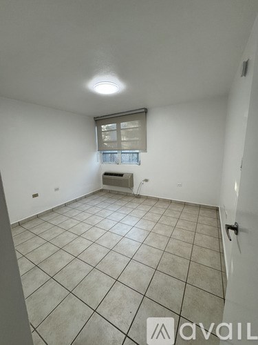 A room with white walls and a tiled floor with a window.