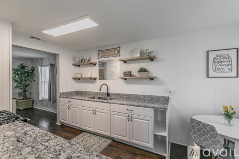 A kitchen with white cabinets and a marble countertop.