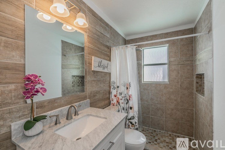 A bathroom with a marble countertop and a large mirror.