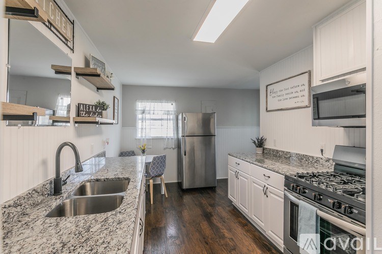 A kitchen with a granite countertop and stainless steel appliances.