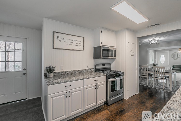 A kitchen with a granite countertop and a framed quote on the wall.