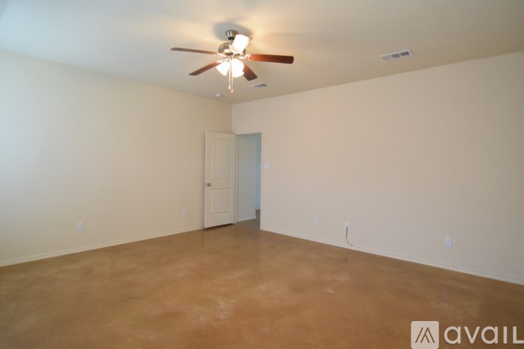 Empty room with a ceiling fan and a door.