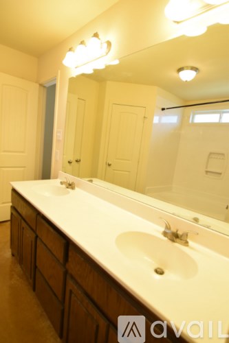 A bathroom with a white counter top and a large mirror.