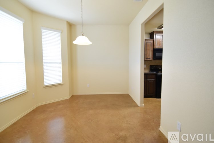 A room with a brown floor and a hanging light fixture.