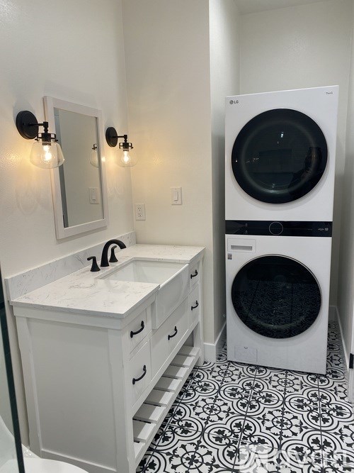 A white sink with a black faucet and a black and white tiled floor.