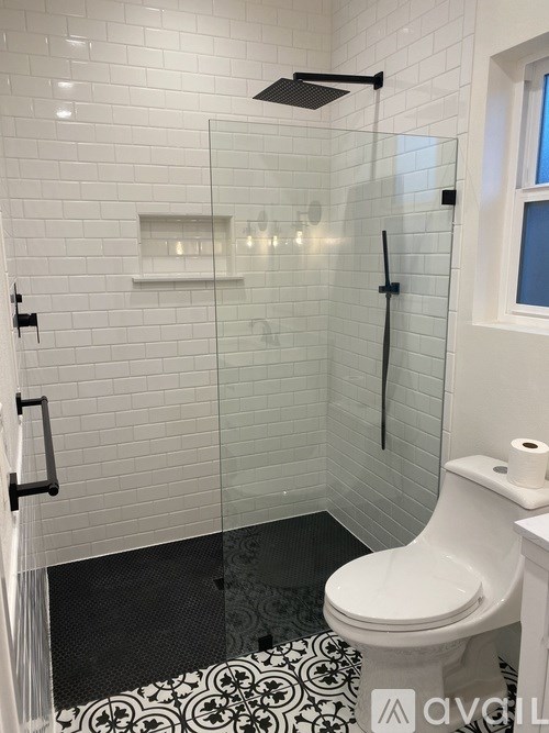 A white toilet in a bathroom with a glass shower door.