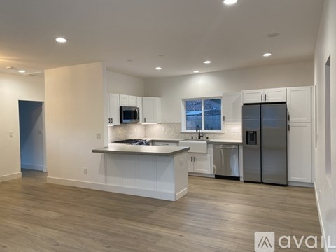 A modern kitchen with white cabinets and stainless steel appliances.