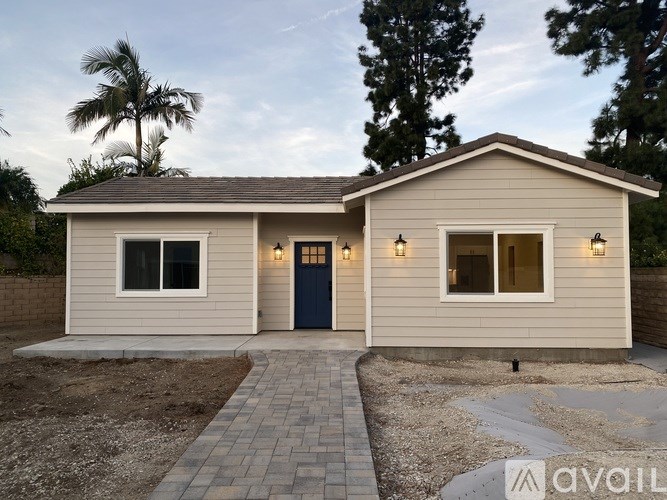 A house with a blue door and windows is available for purchase.