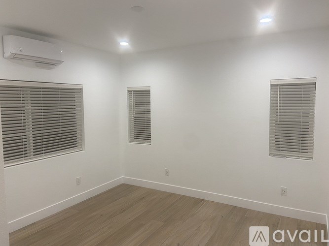 A room with a window and a wall-mounted air conditioner.