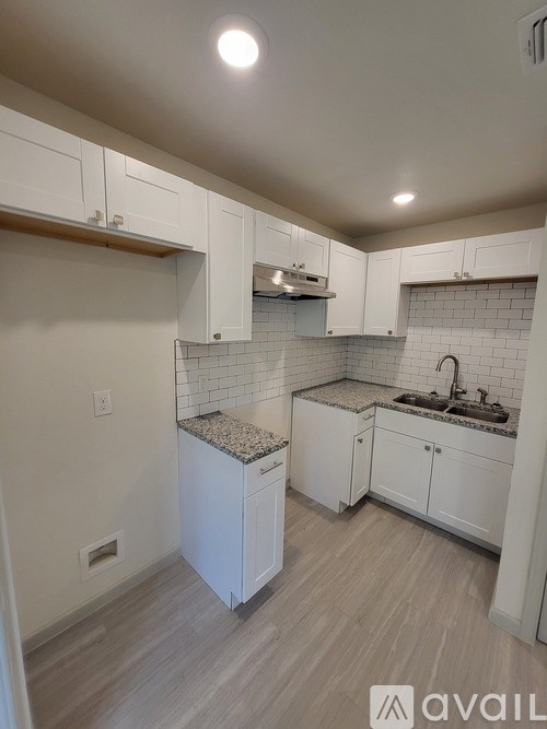 A kitchen with white cabinets and a granite countertop.