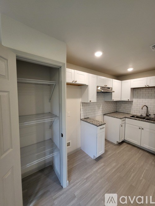 A kitchen with white cabinets and a white fridge is on the market.