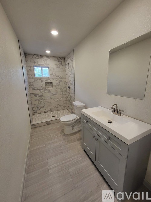 A bathroom with a stone wall and a toilet.