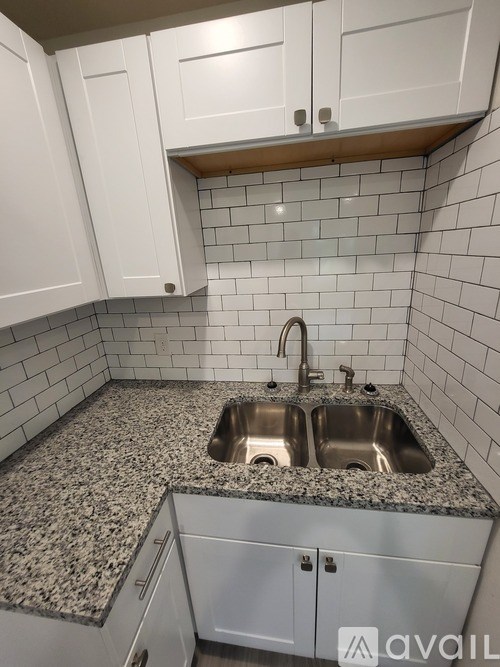 A kitchen with granite countertops and white cabinets.