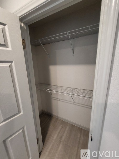 A white closet with shelves and a door.