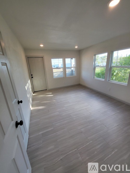 A room with wooden flooring and white walls.