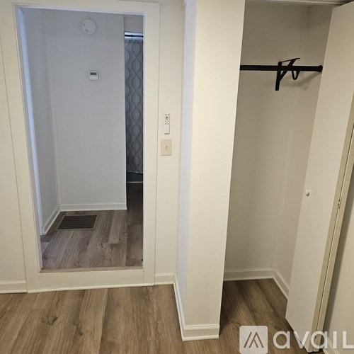 A white door with a black handle and a small square window in the middle.