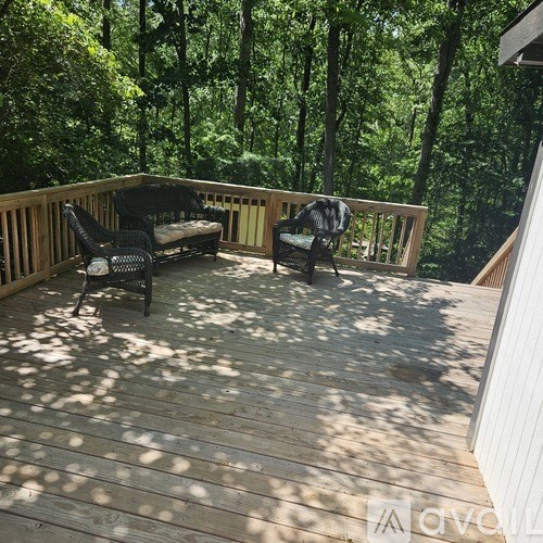 A wooden deck with two chairs and a bench.
