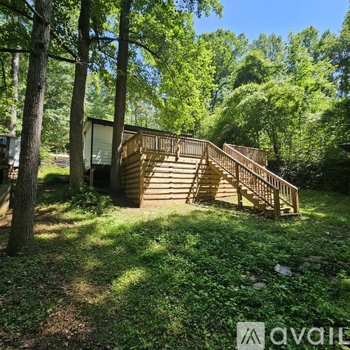 A wooden cabin is nestled in a lush green forest.