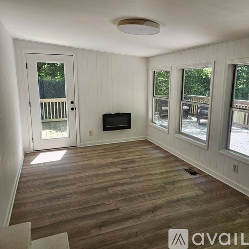 A room with wooden floors and a flat screen TV mounted on the wall.