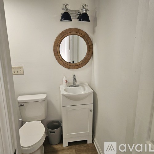 A bathroom with a toilet, a sink, and a mirror.