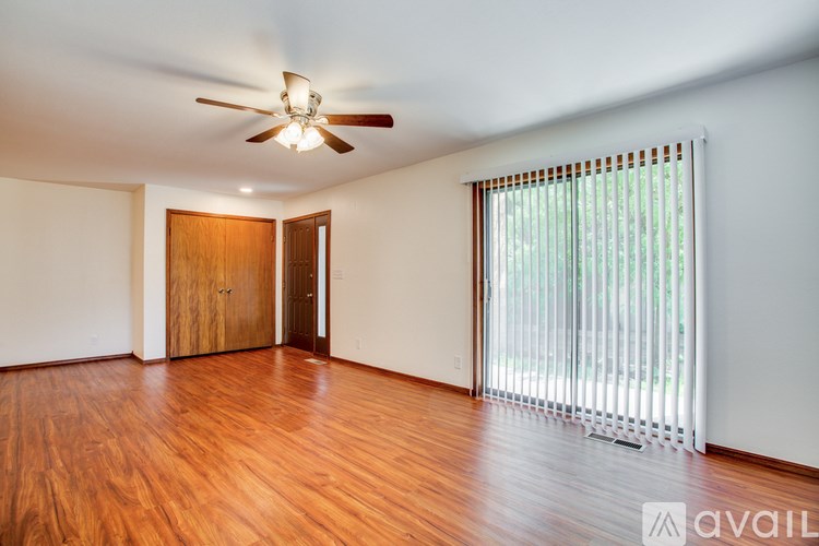 A room with wooden floors and a ceiling fan.