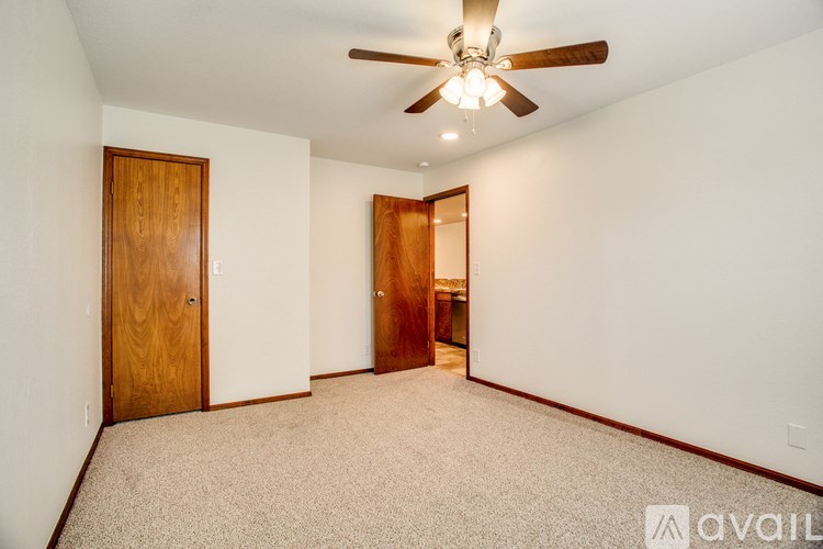 A room with a ceiling fan and two doors.
