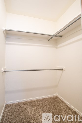 A small, empty room with a carpeted floor and a white wall.