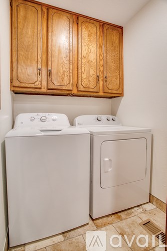 A white dryer and washer in a small laundry room.