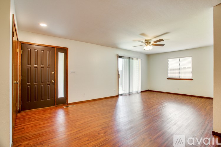 A room with wooden floors and a ceiling fan.