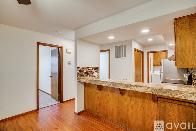 A kitchen with wooden cabinets and a marble countertop.