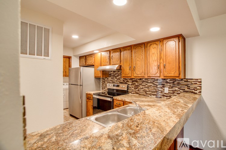 A kitchen with granite countertops and wooden cabinets.
