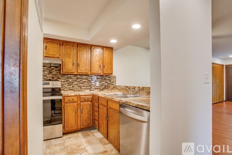 A kitchen with wooden cabinets and a stone backsplash.