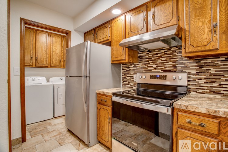 A kitchen with wooden cabinets and a stainless steel refrigerator.