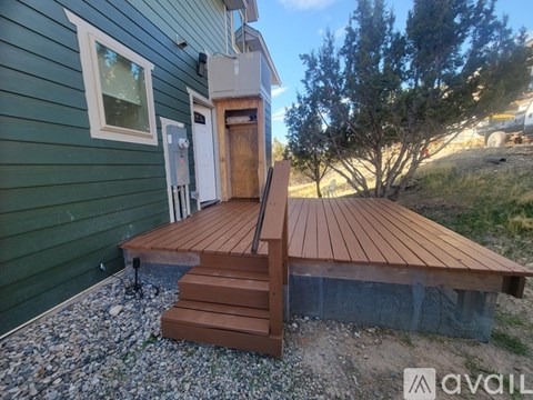 A wooden deck with steps leading to a door.