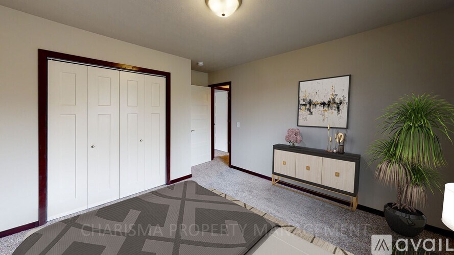 A room with a large rug, a wooden cabinet, and a framed picture on the wall.