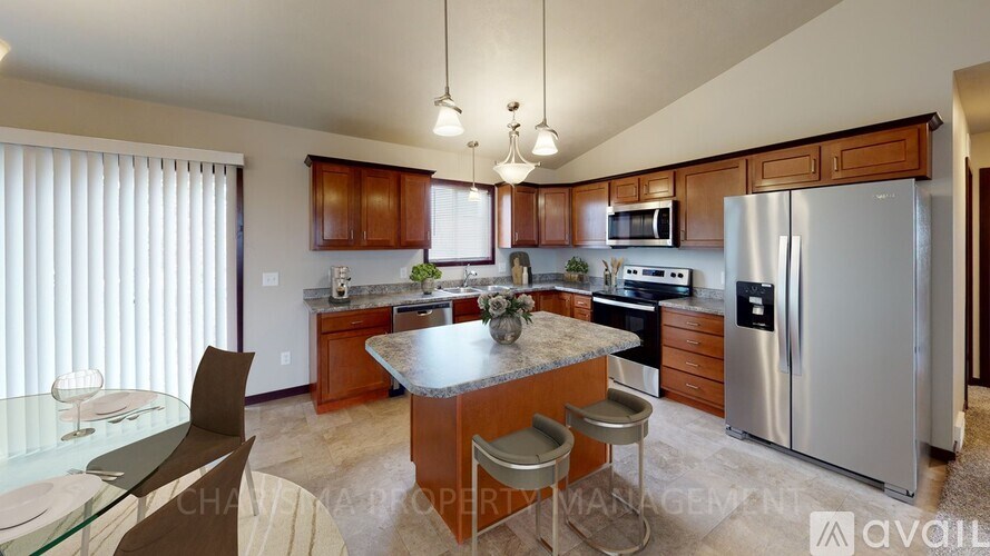 A kitchen with a refrigerator, stove, and dining table.