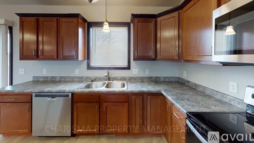 A kitchen with wooden cabinets and a granite countertop.