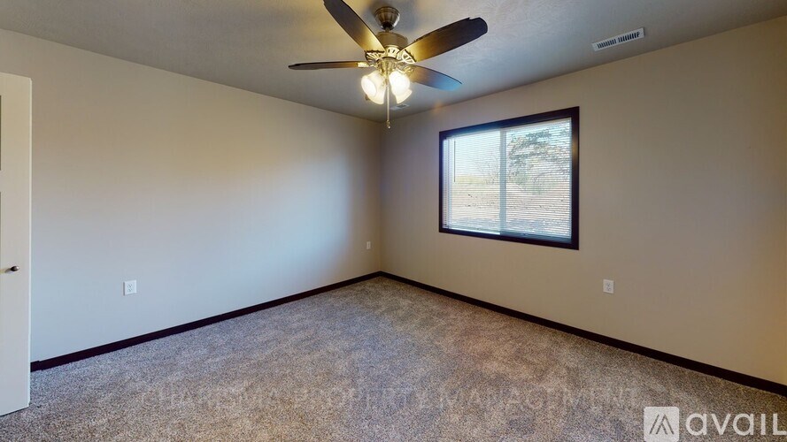 A room with a ceiling fan and a window.